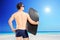 Male surfer holding a surfboard and looking towards the sea