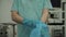 Male surgeon removes gloves and gown after surgery