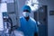 Male surgeon with surgical mask standing in operating room of hospital