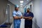 Male surgeons standing at hospital corridor