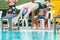 Male swimmer juming of the start platform into the pool