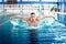 Male swimmer, performing the butterfly stroke technique at indoor pool