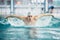 Male swimmer, performing the butterfly stroke technique at indoor pool. vintage effect