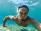 Male swimmer under water in the sea makes selfie