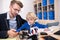 Male teacher and boy sitting at desk, looking buildable car