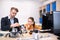 Male teacher fixing buildable car, girl sitting touching her chin