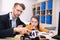 Male teacher pointing at buildable car, girl touching her chin