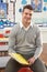 Male Teacher Sitting At Desk In Classroom