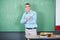 Male Teacher Standing Arms Crossed Against Board