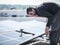 Male team engineers installing stand-alone solar photovoltaic panel system. Electricians mounting blue solar module on roof of