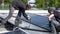 Male team engineers installing stand-alone solar photovoltaic panel system. Electricians mounting blue solar module on roof of