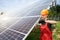 Male technician checks the maintenance of the solar panels. Orange safety cap on his head