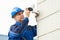 Male Technician Fixing CCTV Camera On Wall