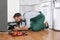 Male technician in uniform repairing refrigerator