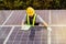 Male technician worker wearing a safety vest works to save the solar panel.