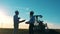 Male technicians are shaking hands near an oil pumping unit