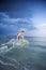 Male teen riding skimboard.