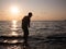 Male Teen Skipping Stones on Sea Water