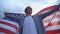 Male teenager with american flag rooting for favorite team, independence day