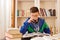 Male teenager drinking coke while studying