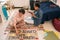 Male teenager with glue stick and his girlfriend preparing climate project paper