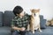 A male teenager sitting with a Shiba Inu on the sofa in the living room. Japanese dog