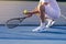 Male tennis player kneeling beside net, no face