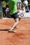 Male tennis player lunging for the ball