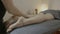 Male therapist massaging the legs of a skinny woman at the salon massage -