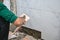 Male tiler using trowel laying marble tile with cement in bathroom. Housing development, improvement renovation