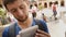 Male tourist concentrated on taking video with mobile phone at square, close-up