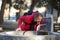 Male tourist drinking mineral water from city fountain in Mestia village on chilly sunny day in late autumn.