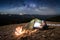 Male tourist enjoying in his camp at night. Man with a headlamp under beautiful sky full of stars and milky way