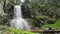 Male tourist having rest near mountain waterfall, wild nature