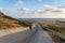 Male tourist hikers on an asphalt mountain road overlooking the sea in Cyprus near Agios Georgios Pegeias. Roadway