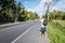 Male tourist hitchhiking on roadside by highway