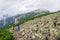 A male tourist with a large backpack climbs a mountain stone path high in  Carpathian