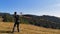 A male tourist launches a drone on top of a mountainside in the Carpathians. A blogger takes pictures of mountains of