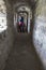 Male tourist in a narrow tunnel of stone walls of an old fortress