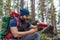 A male tourist pours tea from a thermos during a halt in the forest.