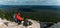 A male tourist is resting after a hard climb up the mountain, panorama. A traveler among the Rocky Mountains. A man is a traveler