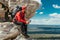 A male tourist is resting after a hard climb up the mountain. A traveler among the Rocky Mountains. A man is a traveler