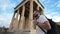 Male tourist spends time on walking among pillars of ancient Acropolis in Athens