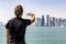 Male tourist takes a picture of the skyline of Doha, Qatar