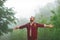 Male tourist on top of mountain in fog in autumn