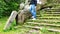 Male tourist touches the hand of a stone statue of a lion