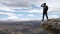 a male tourist traveler on a hill overlooking the mountain range of the Caucasus Mountains Elbrus stands boldly on a