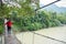 Male Tourist Walking on Suspension Bridge in Tangkahan River, In