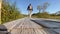 male tourist walks along the wooden deck in the park in spring