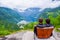 Male tourists sitting on the Queen Sony Chair at the Flydalsjuvet Viewpoint. The Geiranger village and Geirangerfjord landscape.